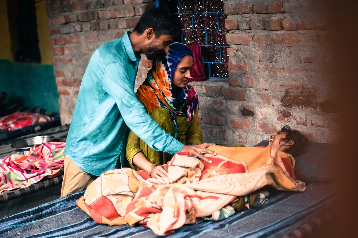 Naseeba and her husband Mussadi play with their daughter in the refugee settlement in Majnu ka Tila, New Delhi.
