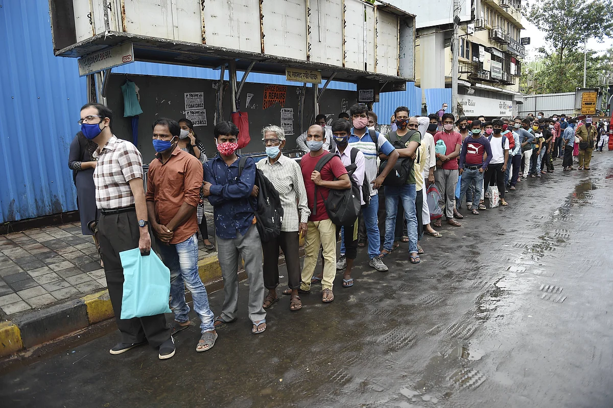 People wait in a queue for a bus after unlocking of COVID-19 lockdown began in a phased manner, at Bandra in Mumbai.
