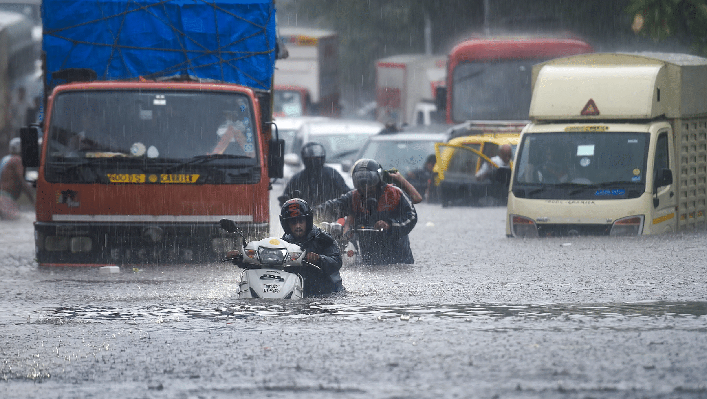 Vehicles ply through a  waterlogged road due to heavy rain in Thane on 9 June.