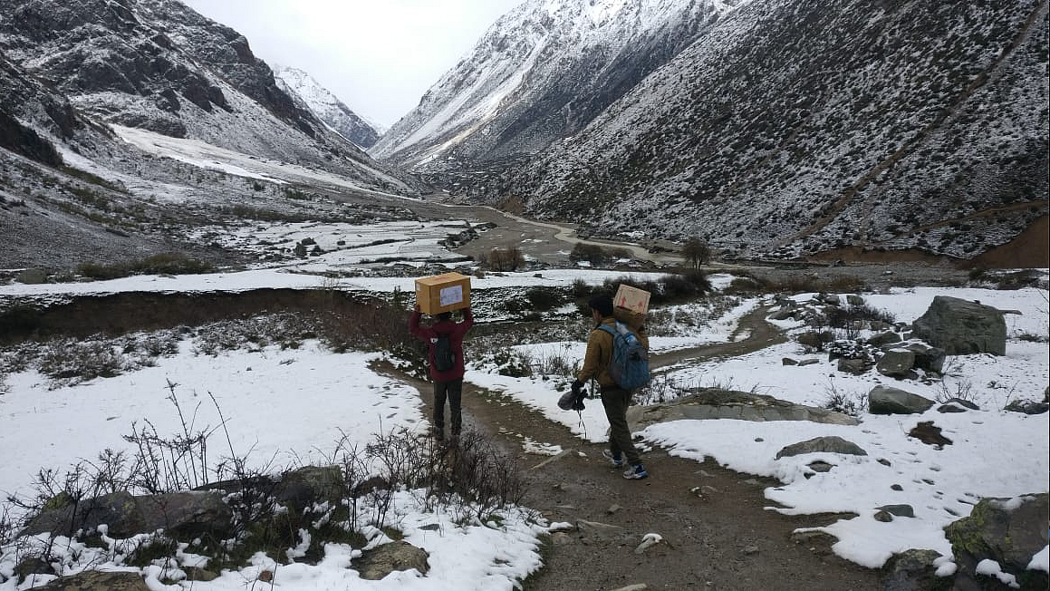 Volunteers carry COVID-relief Kits on their shoulders.
