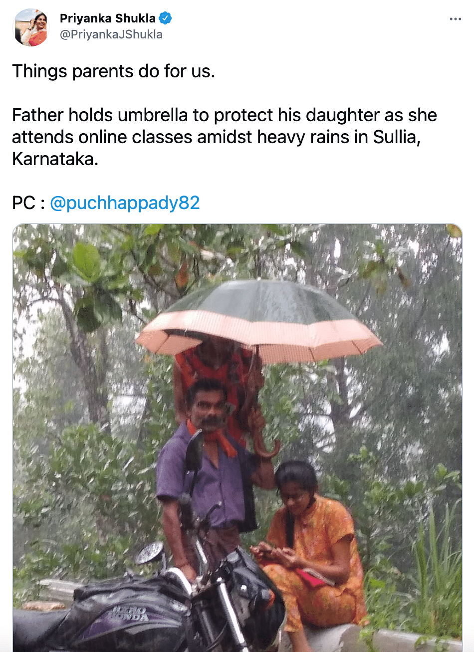The picture of a father holding an umbrella for his daughter in the rain has gone viral.