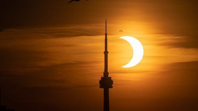Sun appeared a crescent during sunrise from the Toronto lakeshore.