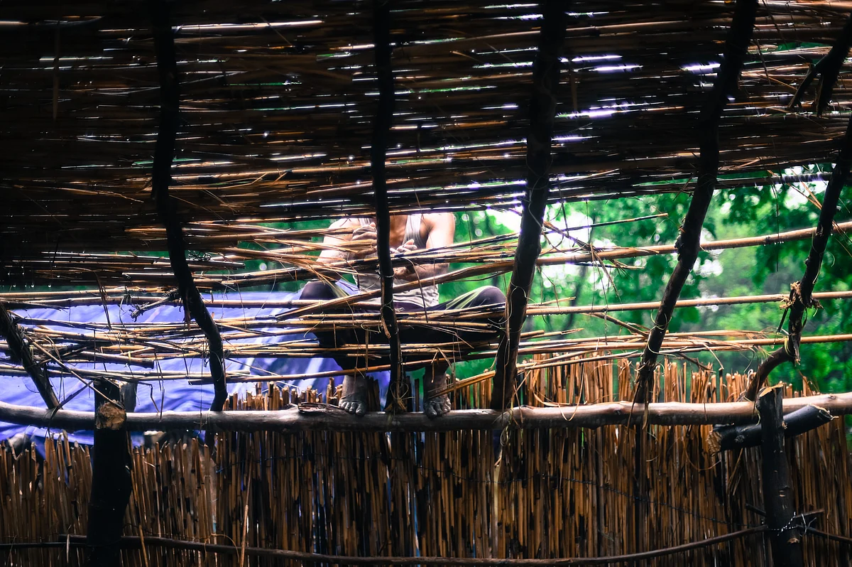 A man repairs the roof of a temporary housing shelter at the Signature bridge refugee camp in New Delhi.