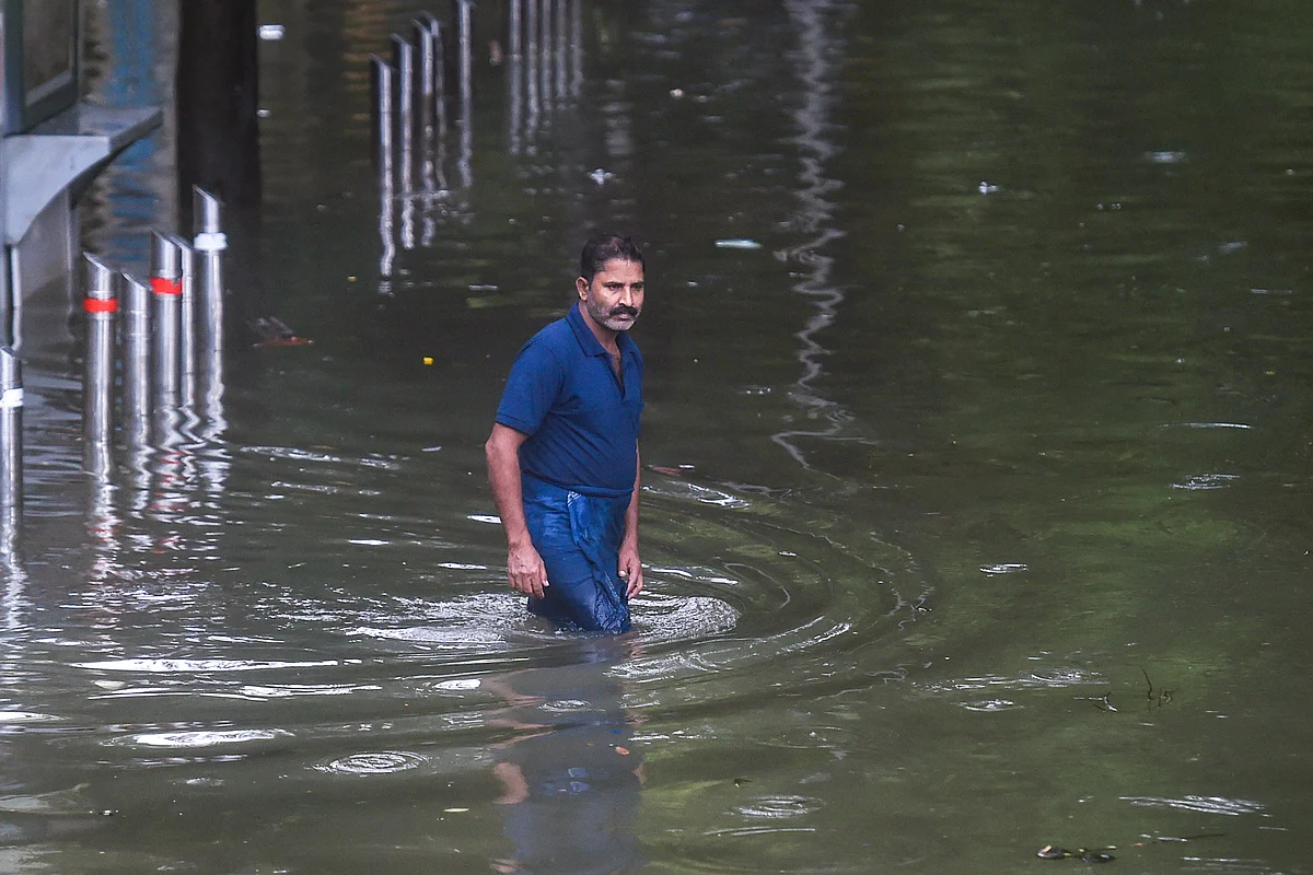 <div class="paragraphs"><p>A man wades through a waterlogged street at Parel after heavy rains in Mumbai, 18 July.</p></div>