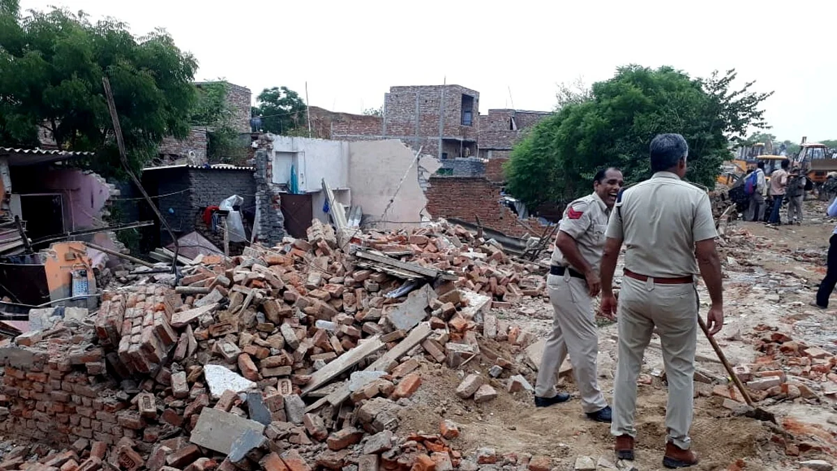 <div class="paragraphs"><p>As houses in the Khori Village are razed to the ground, Faridabad Police officials look on.</p></div>