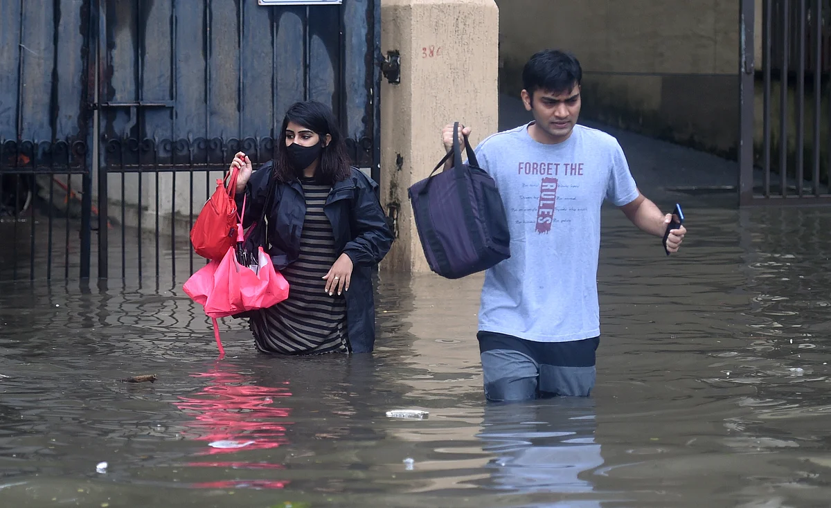 <div class="paragraphs"><p>Mumbai: People make their way through the waterlogged streets at Kings Circle, in Mumbai<br></p></div>