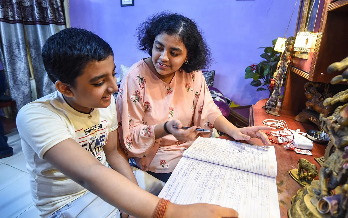 <div class="paragraphs"><p>Vanisha Pathak, who emerged as a topper in the class X CBSE exams, helps her brother with his studies in Bhopal.</p></div>