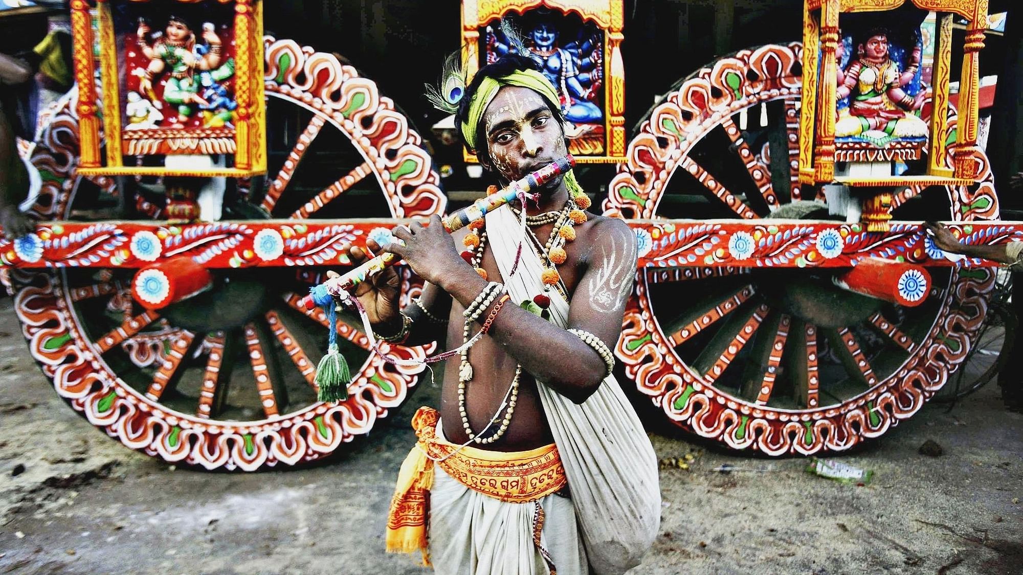 <div class="paragraphs"><p>A devotee in the attire of Lord Krishna poses for a photo near a chariot.  </p></div>