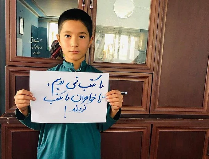 <div class="paragraphs"><p>An Afghan boy holding a placard that reads, "We don't go to school without our sisters."</p></div>