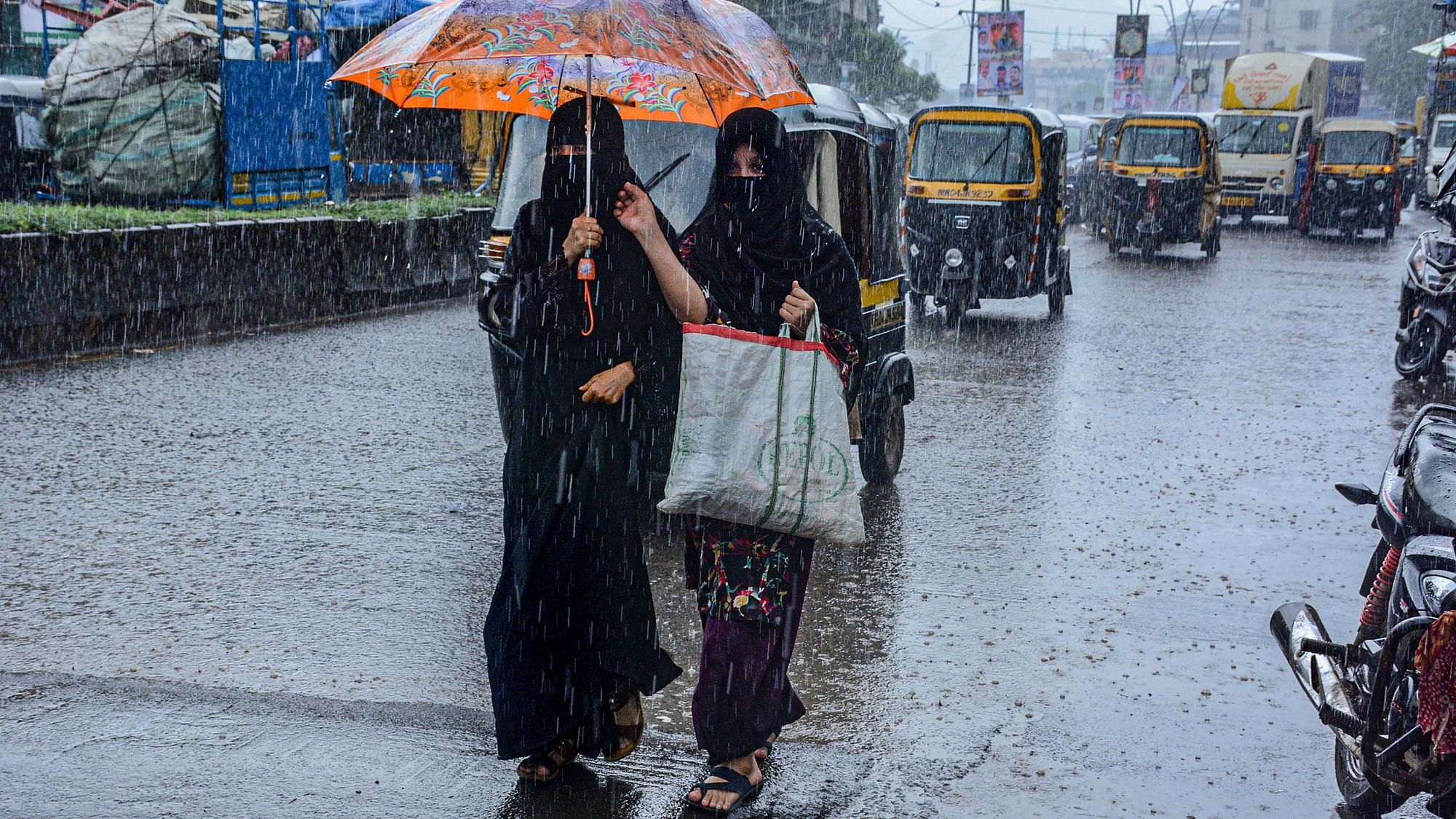 <div class="paragraphs"><p>Thane: Women walk under an umbrella during rains due to cyclone Gulab's influence at Mumbra in Thane on Tuesday.</p></div>