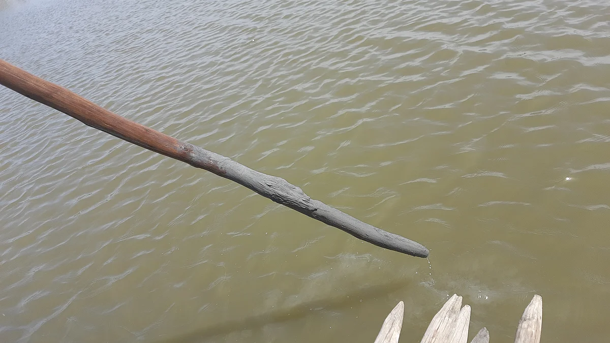 <div class="paragraphs"><p>When the fisherman put the stick in the water, it showed how there were several layers of ash that had accumulated in the river bed.</p></div>