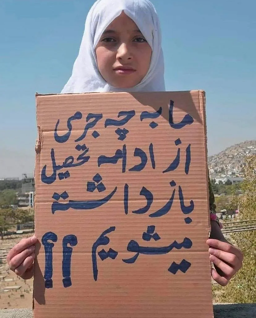 <div class="paragraphs"><p>A girl with a placard that reads, "What is our crime for being barred from continuing education?"</p></div>