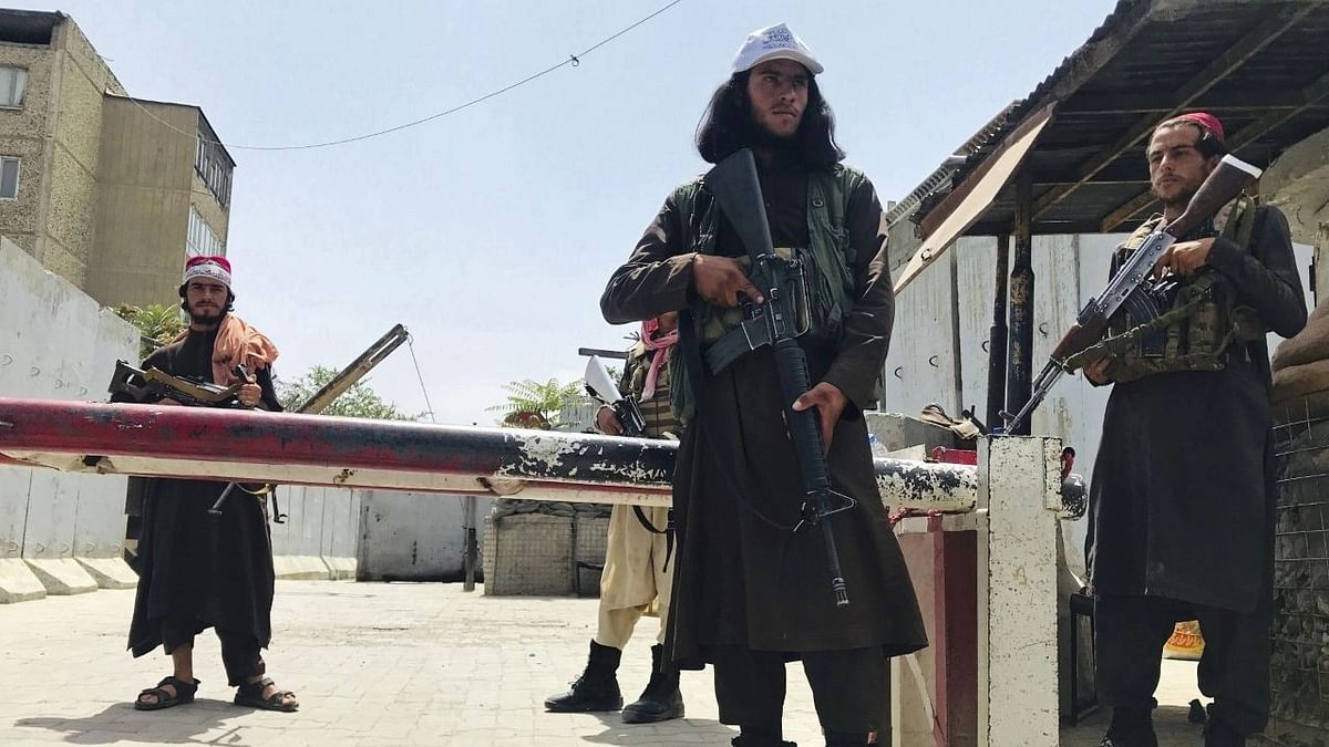<div class="paragraphs"><p>Taliban fighters stand guard at a checkpoint near the US embassy.</p></div>
