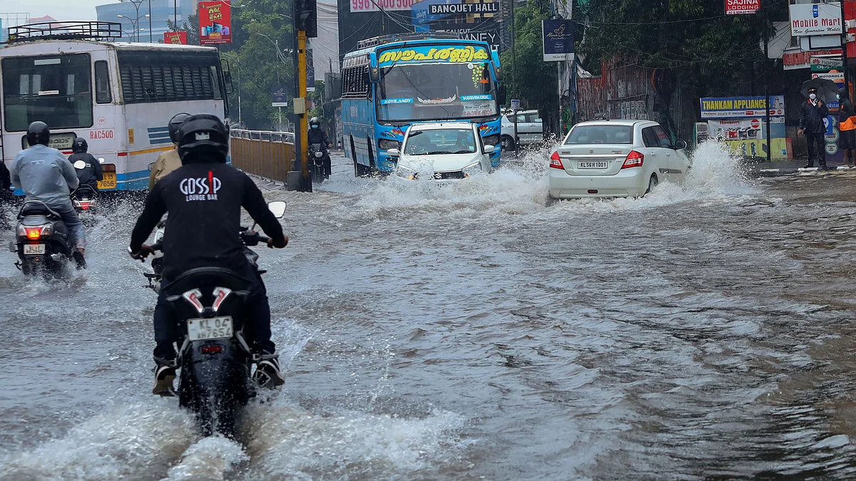 <div class="paragraphs"><p>Commuters wade through a waterlogged road during heavy rain in Kozhikode, Kerala.</p></div>