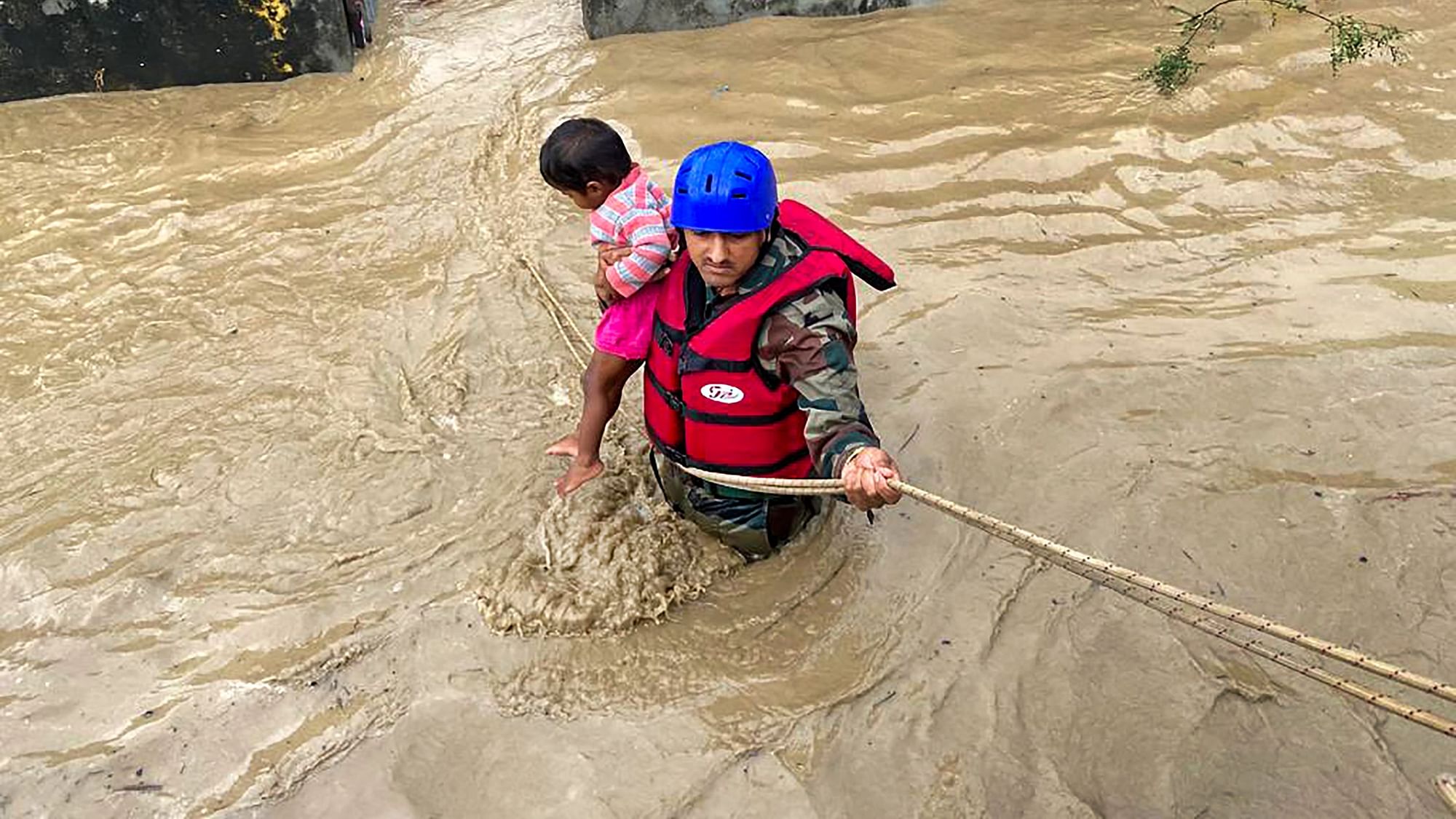 <div class="paragraphs"><p>Indian Army jawan rescues a child and villagers stranded in flood-water in Tanakpur, Uttarakhand on Wednesday, 20 October.</p></div>