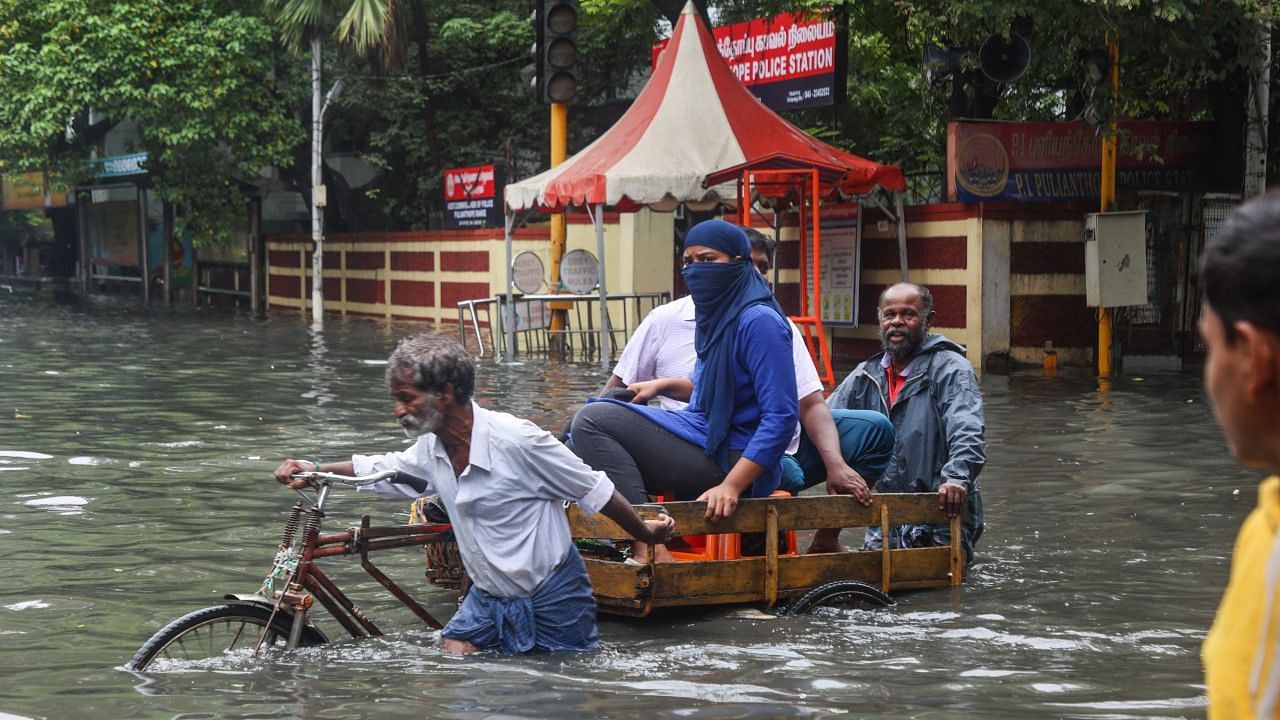 <div class="paragraphs"><p>A worker pulls a rickshaw with passengers through a waterlogged area following heavy rain in Chennai.</p></div>