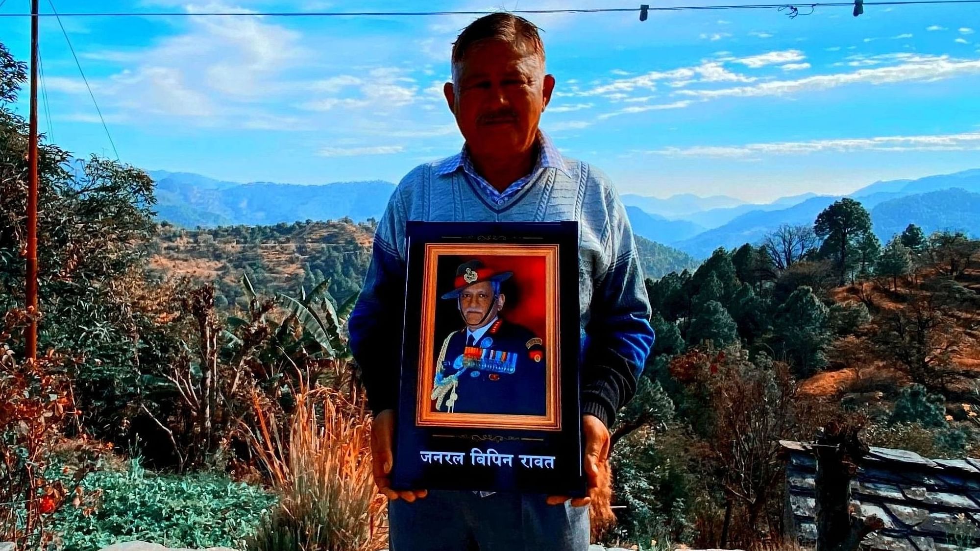 <div class="paragraphs"><p>Bharat Singh Rawat stands with a picture of the late CDS, Gen. Bipin Rawat.&nbsp;</p></div>
