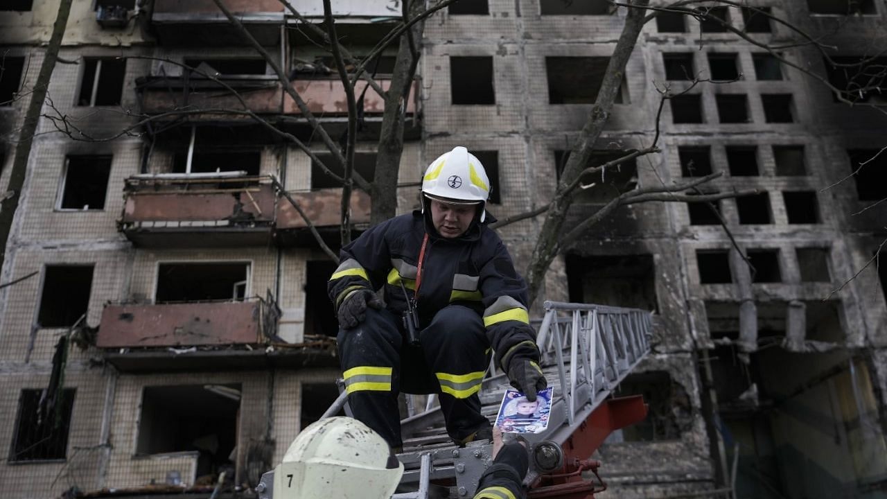 <div class="paragraphs"><p>Ukrainian firefighters hold a photograph, found in the rubble, as they work in a resident building after it was hit by artillery shelling in Kyiv, Ukraine, Monday, 14 March.</p></div>
