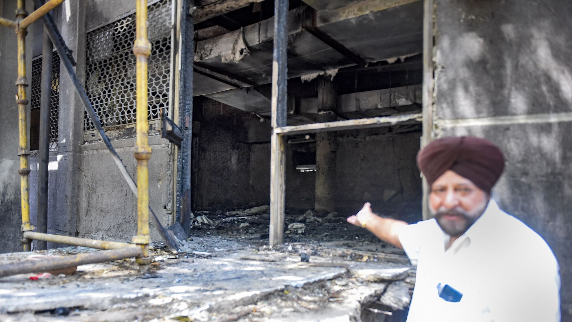 <div class="paragraphs"><p>A man shows charred remains after a fire at Uphaar Cinema, which has been shut since 1997, in New Delhi on 17 April.</p></div>