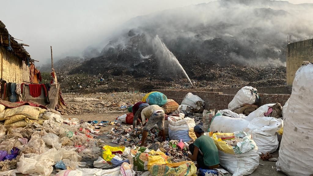 <div class="paragraphs"><p>Four days since, despite ongoing attempts to douse the flames, plumes of dark acrid smoke continues to fill up the air around the Bhalswa landfill, as the massive mound of garbage dump could be seen speckled with smaller fires.</p></div>