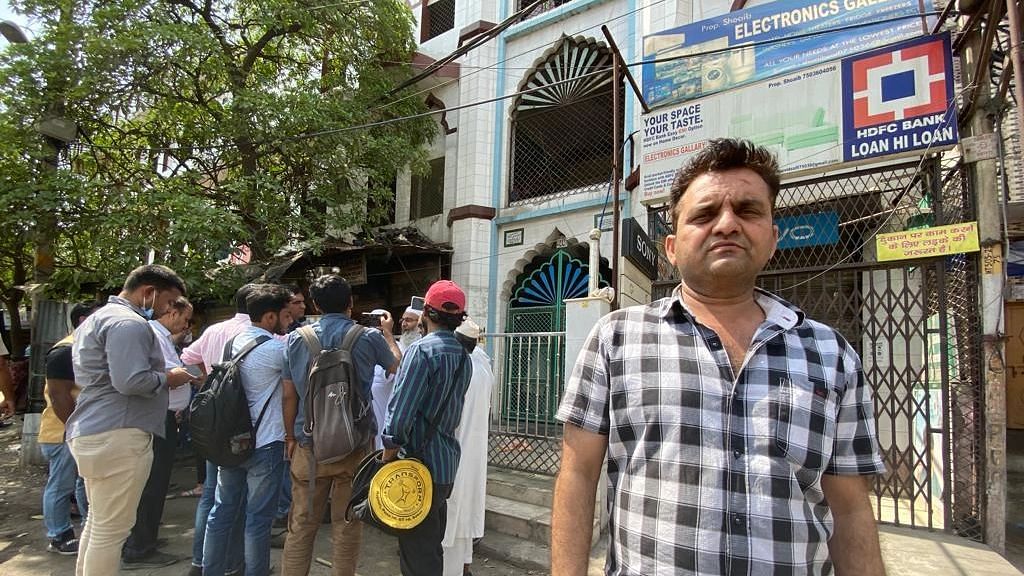 <div class="paragraphs"><p>Sajid Saifi outside his shop next to the mosque at the heart of the violence.</p></div>