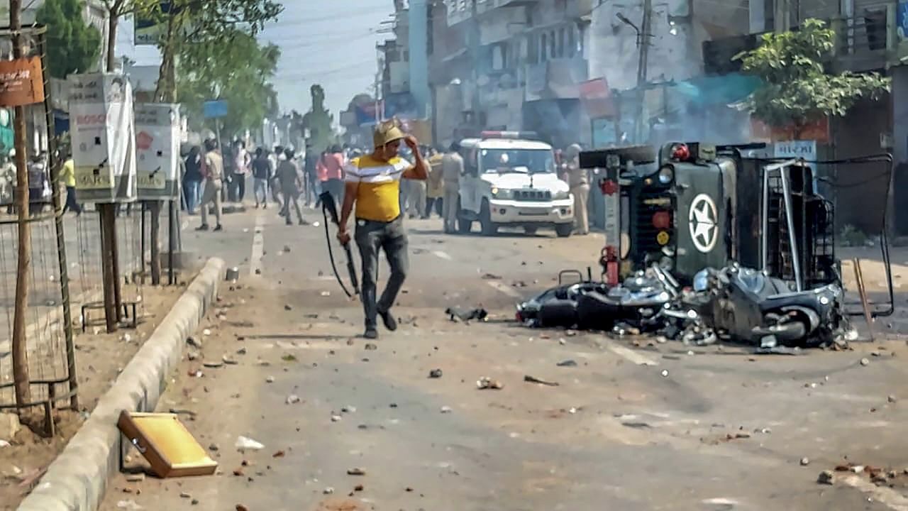 <div class="paragraphs"><p>A policeman near a burnt vehicle as police try to control the situation after a communal clash during the Ram Navami procession, in Himmatnagar.</p></div>