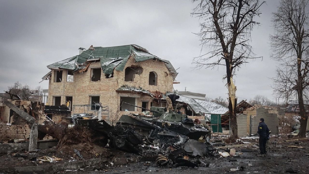 <div class="paragraphs"><p>A man looks at the gutted remains of Russian military vehicles on a road in the town of Bucha.</p></div>