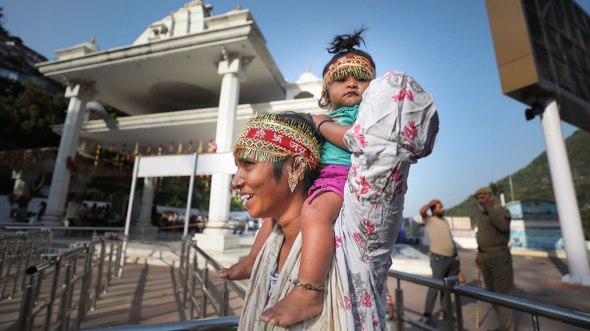 <div class="paragraphs"><p>A woman carries her child as she walks towards Mata Vaishno Devi shrine on the first day of Chaitra Navratri festival, at Katra in Reasi district on Saturday, 2 April.</p></div>