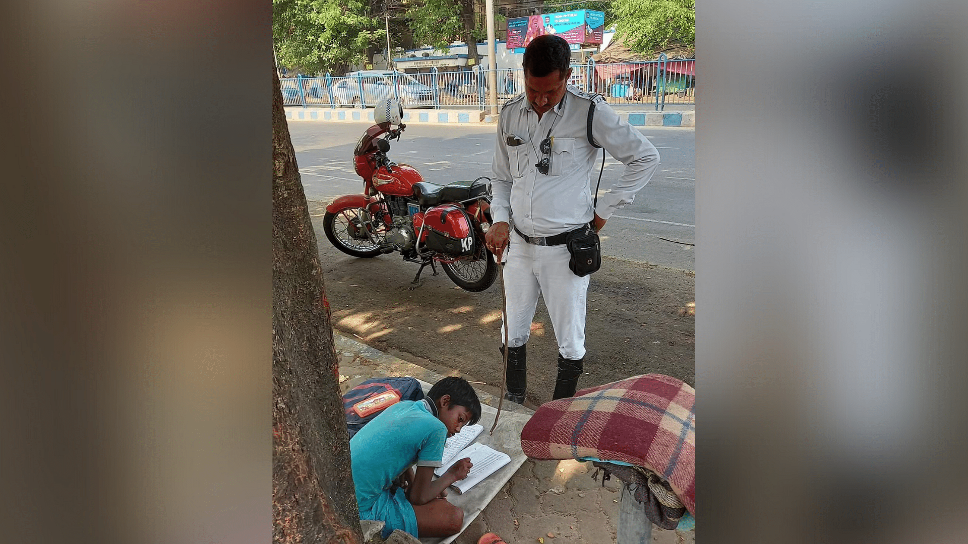 <div class="paragraphs"><p>Sergeant Prakash Ghosh teaches a boy while managing traffic.</p></div>