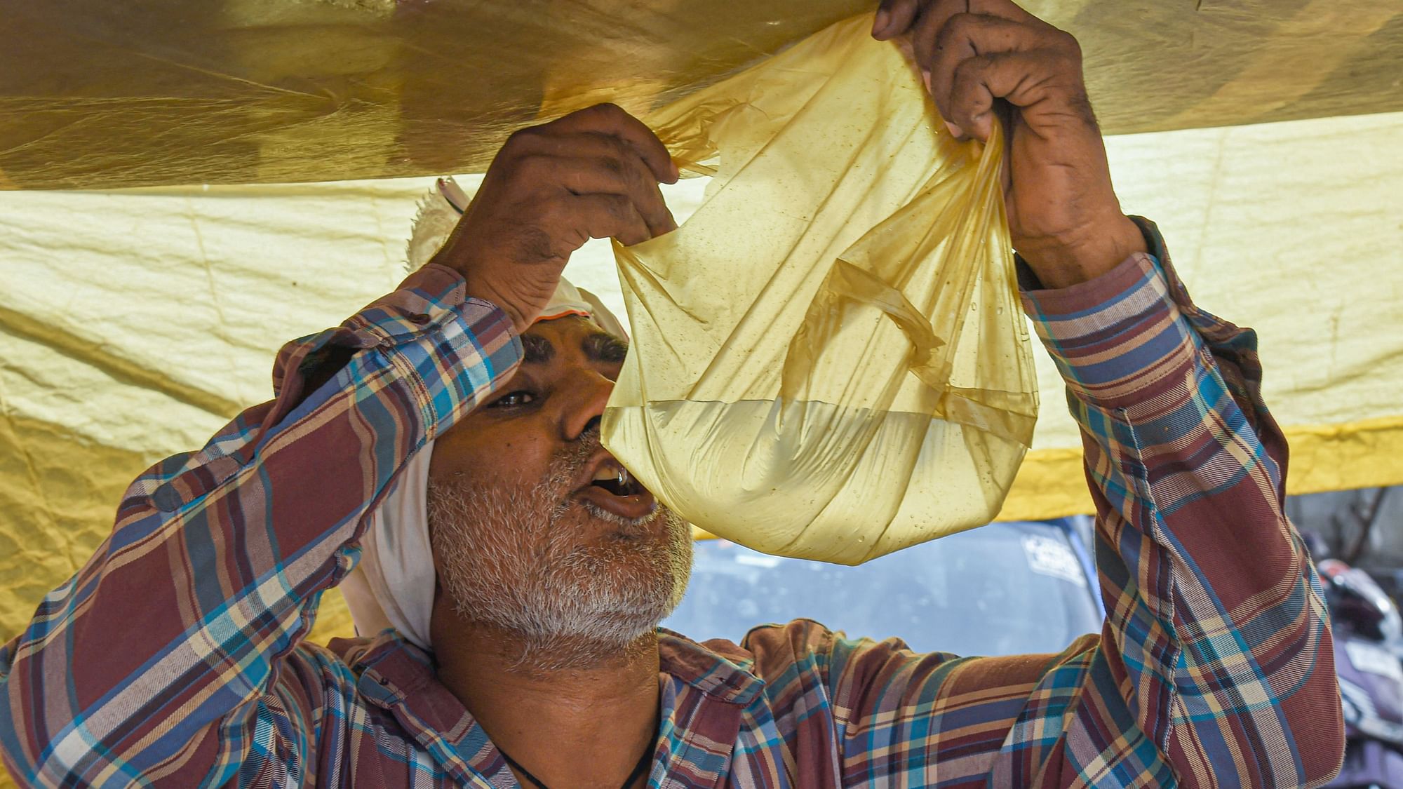 <div class="paragraphs"><p>A man drinks water from a polybag to quench his thirst on a hot summer day, in New Delhi. Image for representational purposes.</p></div>