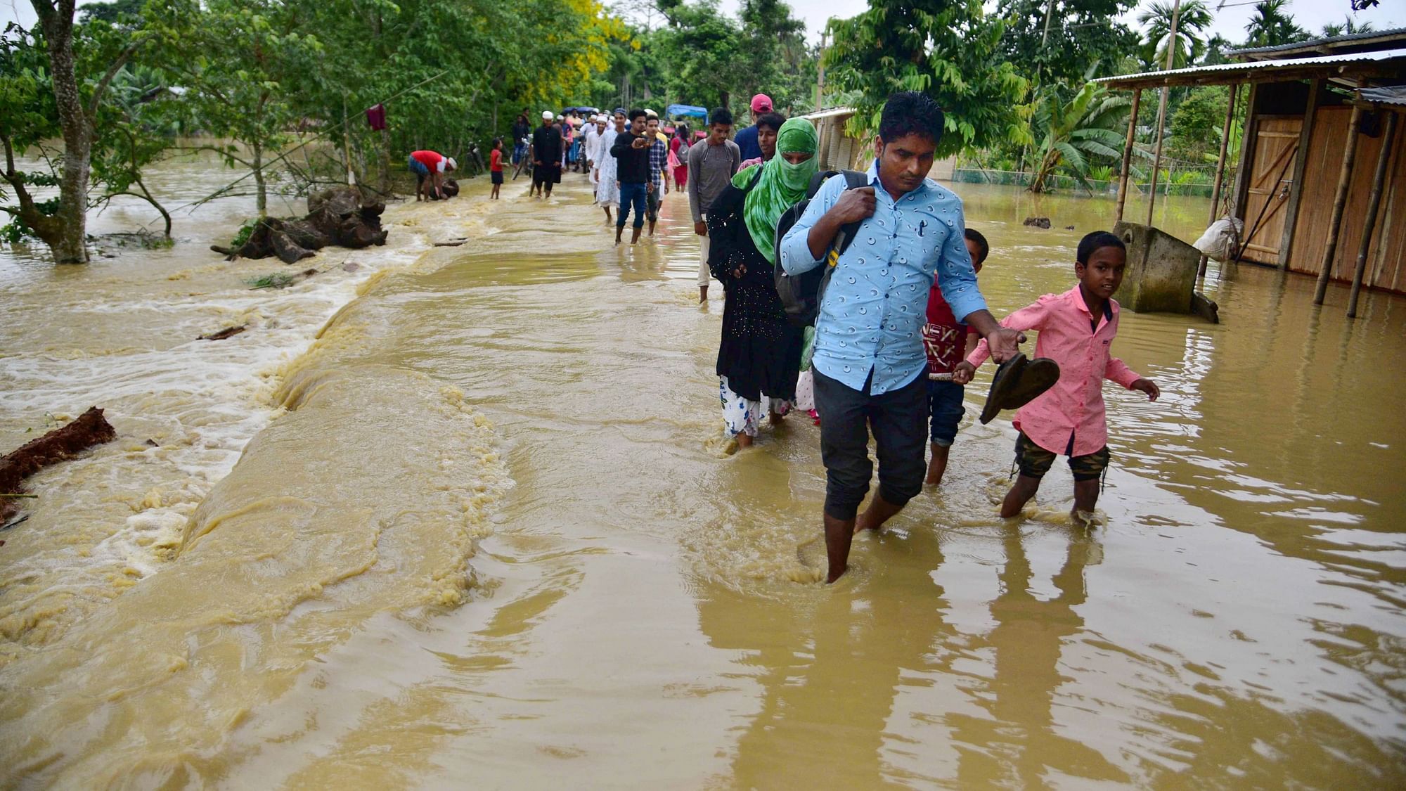 <div class="paragraphs"><p>Villagers wade through a flood-affected area following heavy rains in Hojai district of Assam.</p></div>