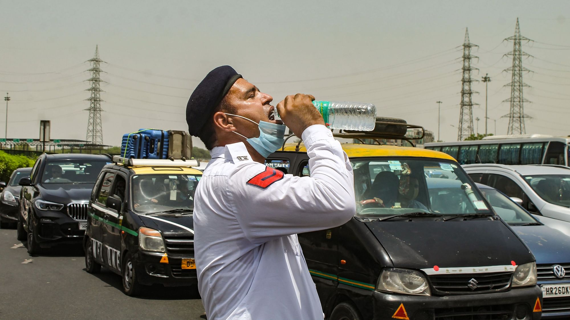 <div class="paragraphs"><p>A traffic policeman drinks water to quench his thirst during a heatwave spell, on the Delhi-Gurugram Expressway in Gurugram.</p></div>