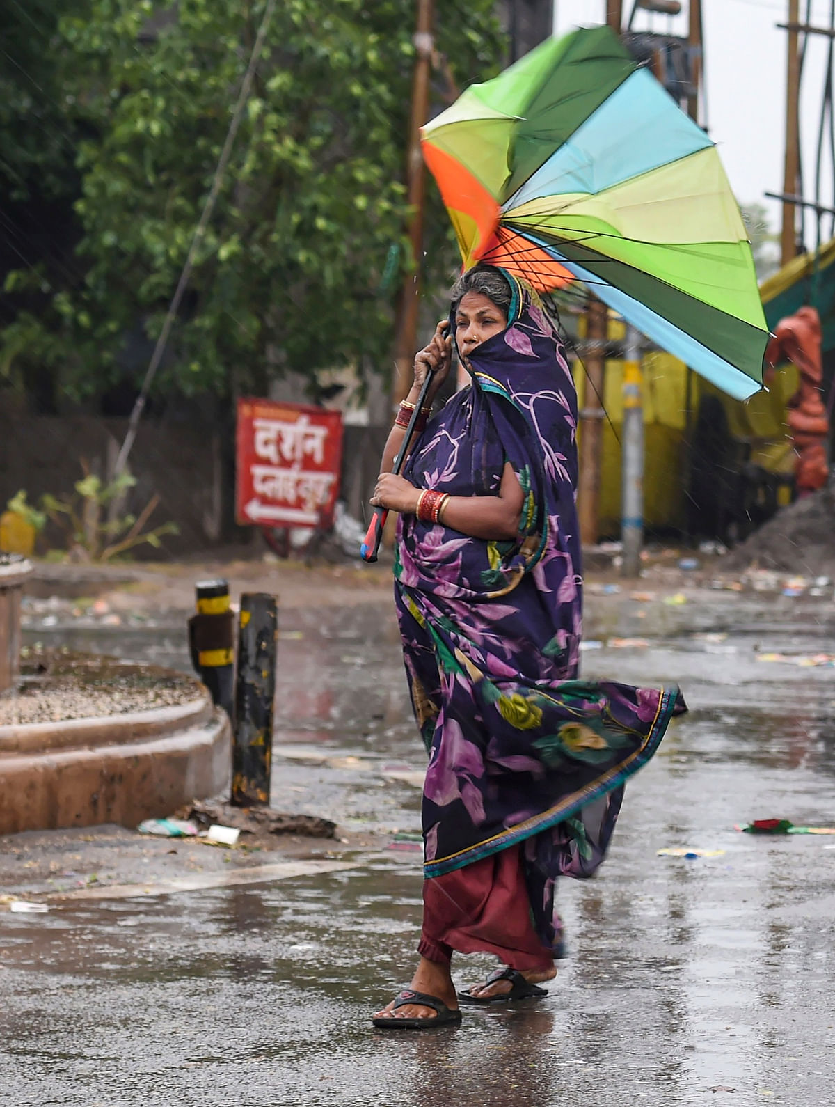 <div class="paragraphs"><p>A woman holds a damaged umbrella, as she tries to shield herself from the rain in Ghaziabad on 23 May.</p></div>