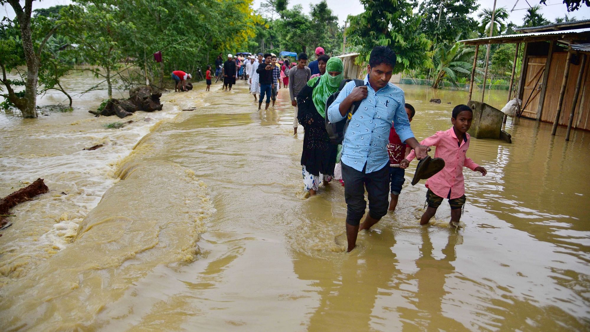 <div class="paragraphs"><p>Villagers wade through a flood affected area following heavy rains in Hojai district of Assam.&nbsp;</p></div>