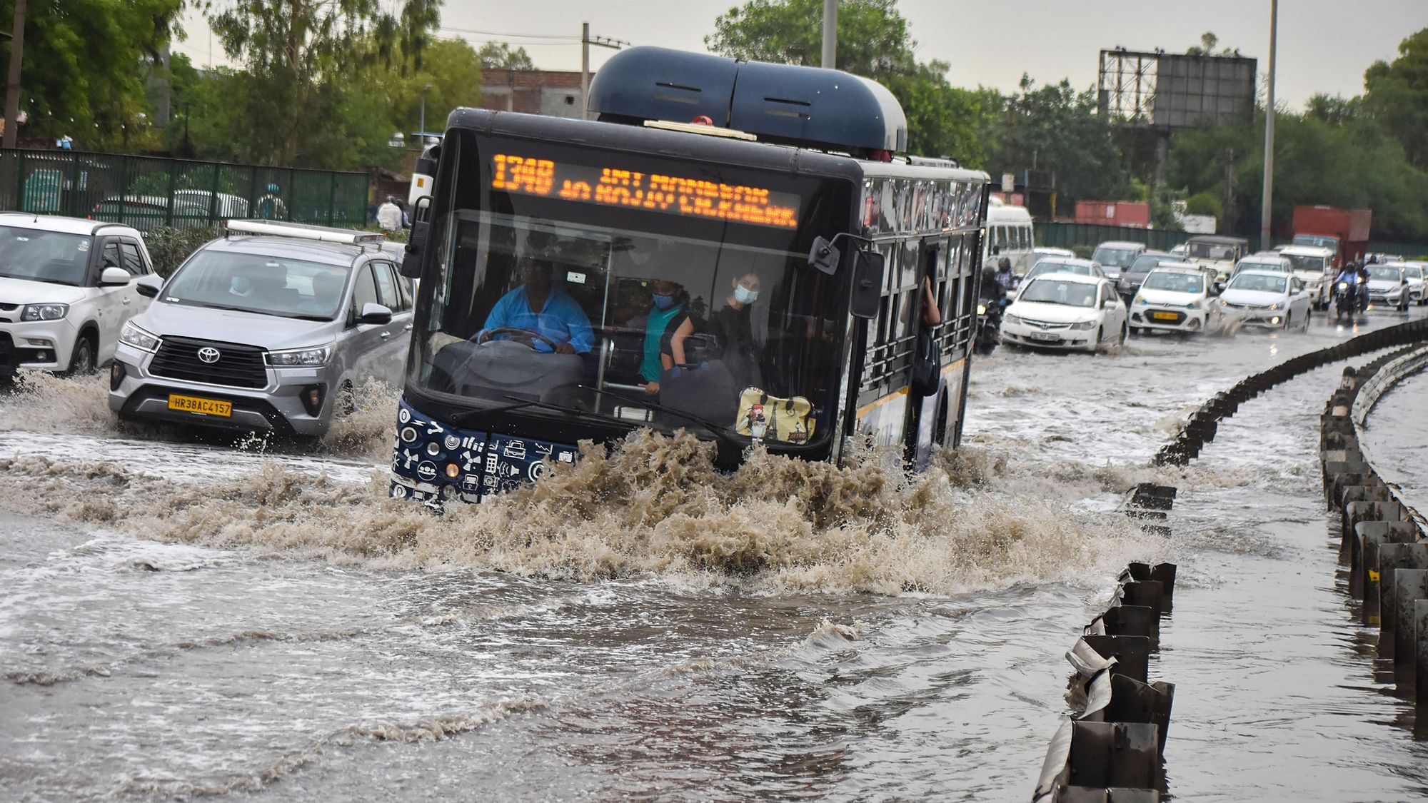 <div class="paragraphs"><p>Vehicles wade through a waterlogged street after heavy rains in Gurugram on Monday.</p></div>