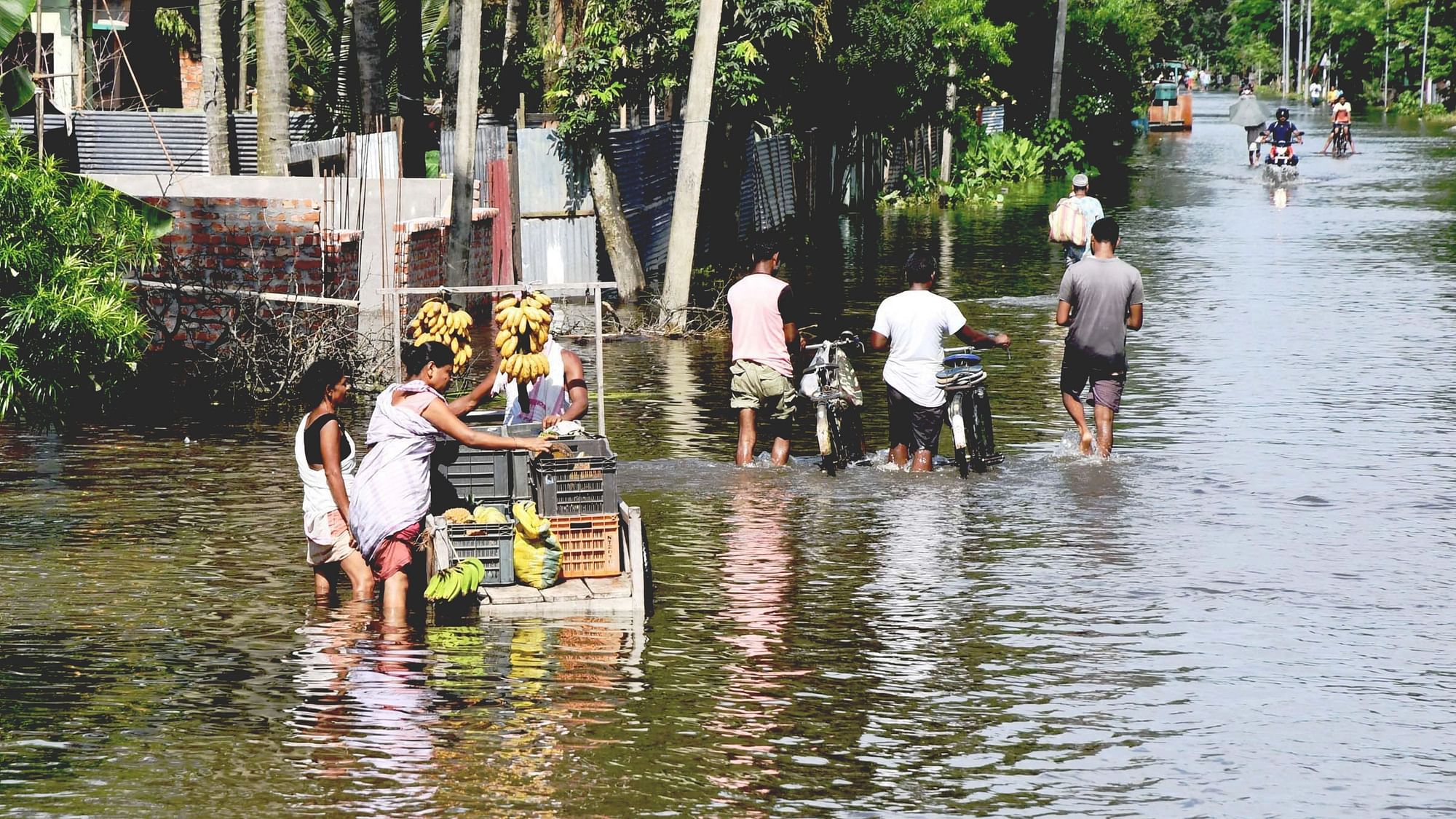 <div class="paragraphs"><p>A vendor wades through a flooded street in Kamrup district, Assam on Friday, 24 June</p></div>