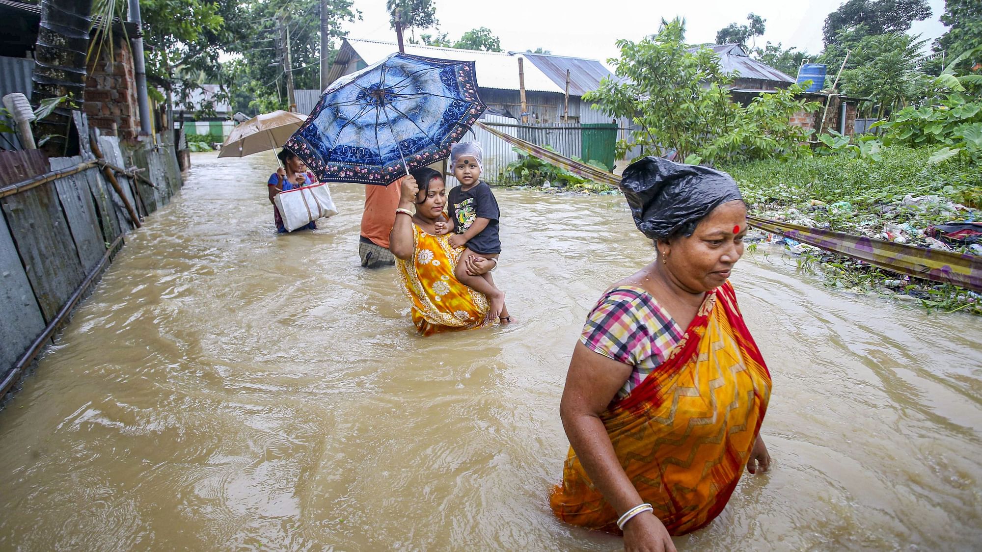 <div class="paragraphs"><p>Villagers move to a safer place from a flood-affected area following heavy rains, at Baldakhal village, on the outskirts of Agartala on Saturday, 18 June.</p></div>