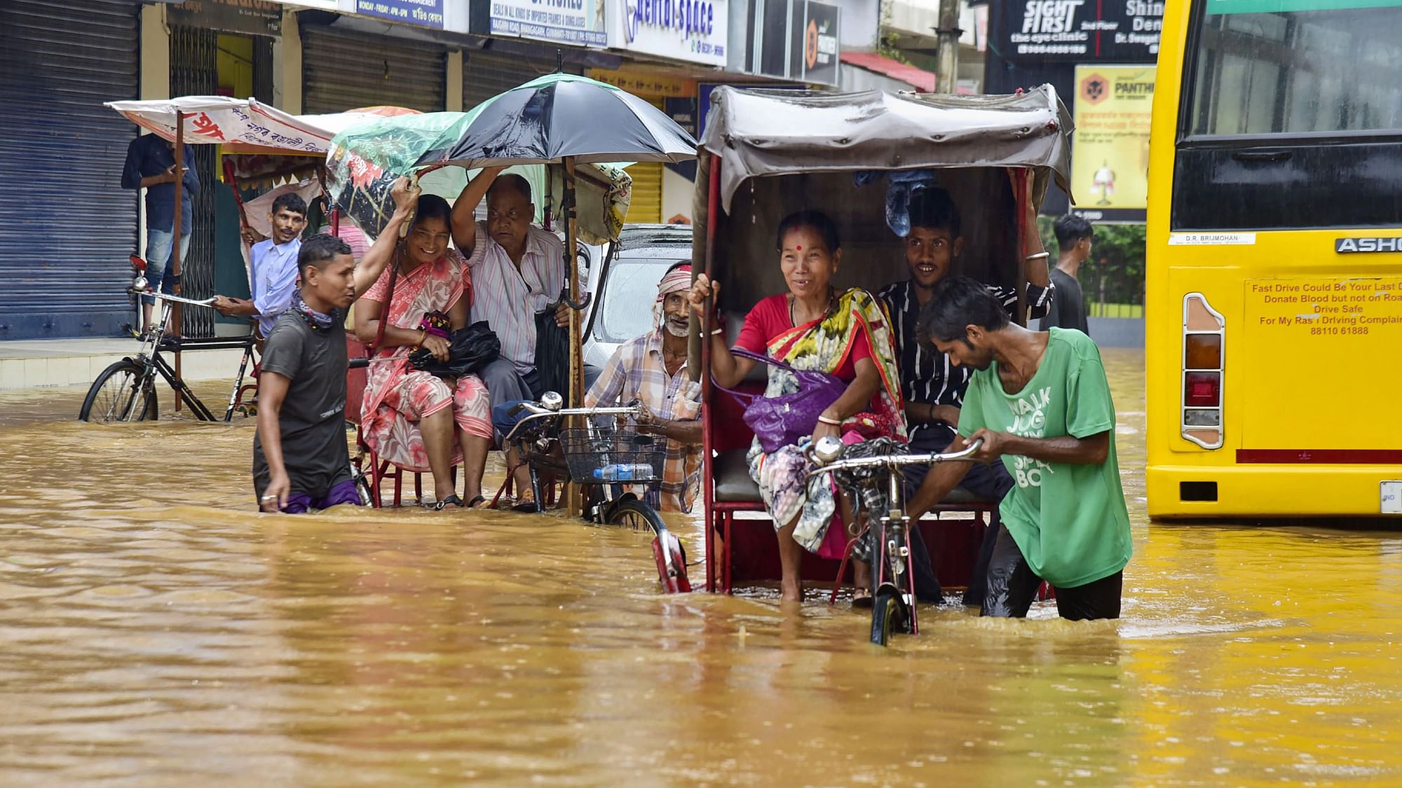 <div class="paragraphs"><p>Cycle rickshaw drivers wade through a flooded street after rains in Guwahati.</p></div>