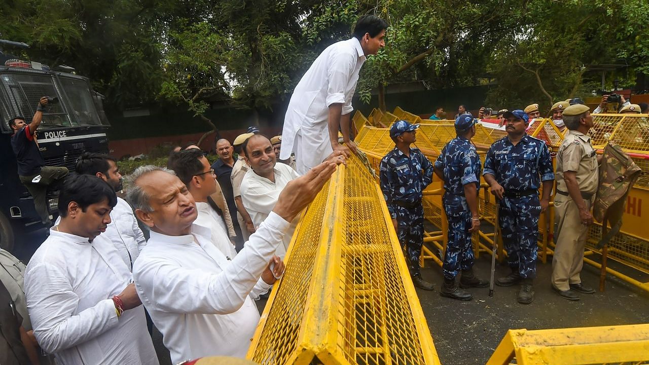 <div class="paragraphs"><p>Rajasthan Chief Minister Ashok Gehlot with Congress leader Deepender Singh Hooda stand near a police barricade during their protest march from AICC to ED office.</p></div>
