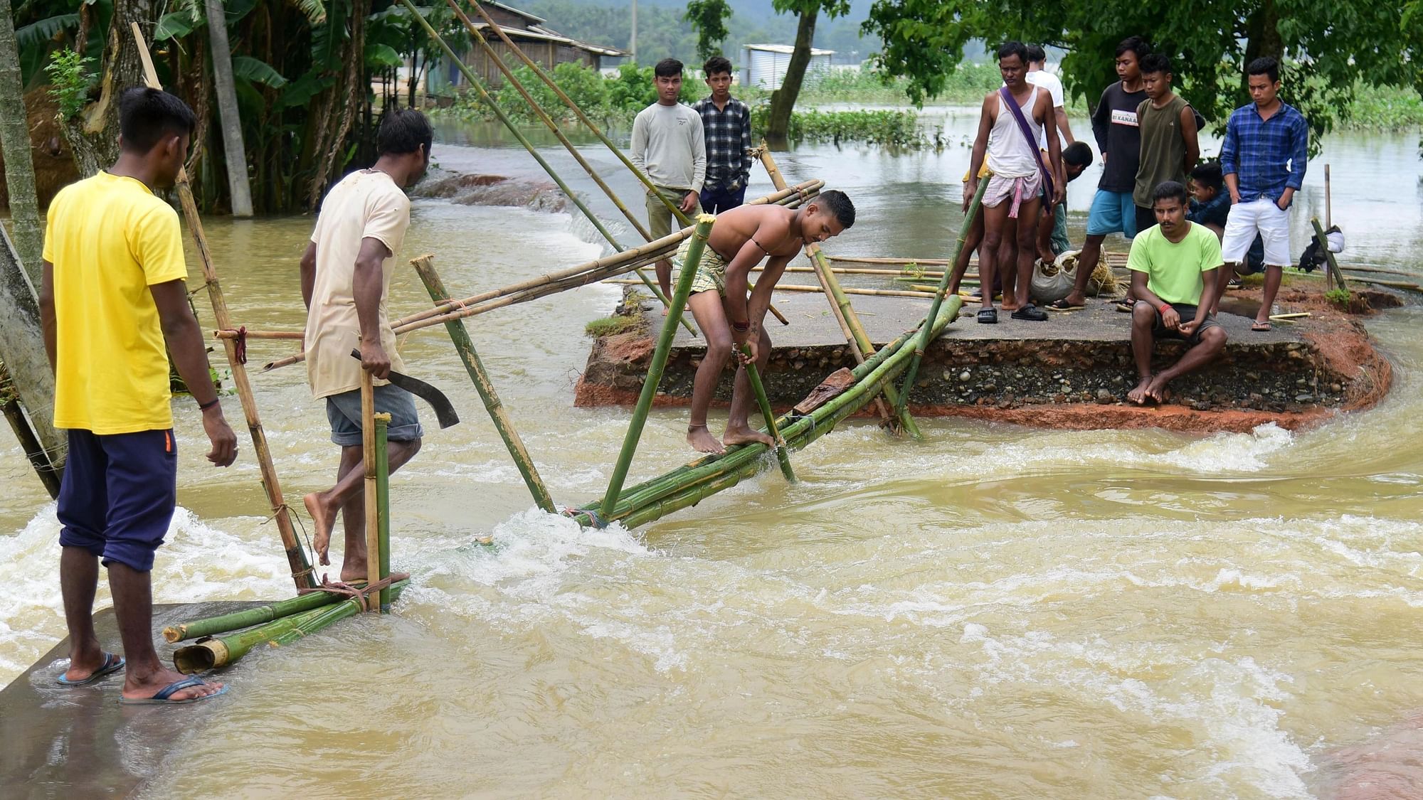<div class="paragraphs"><p>Villagers make a temporary bamboo bridge after a portion of a road was washed away by the floods at a village in Goalpara district in Assam.</p></div>