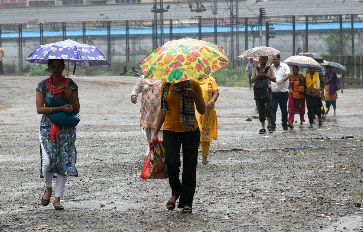 <div class="paragraphs"><p>Pedestrians holding umbrellas walk on the road amid rains in New Delhi.</p></div>