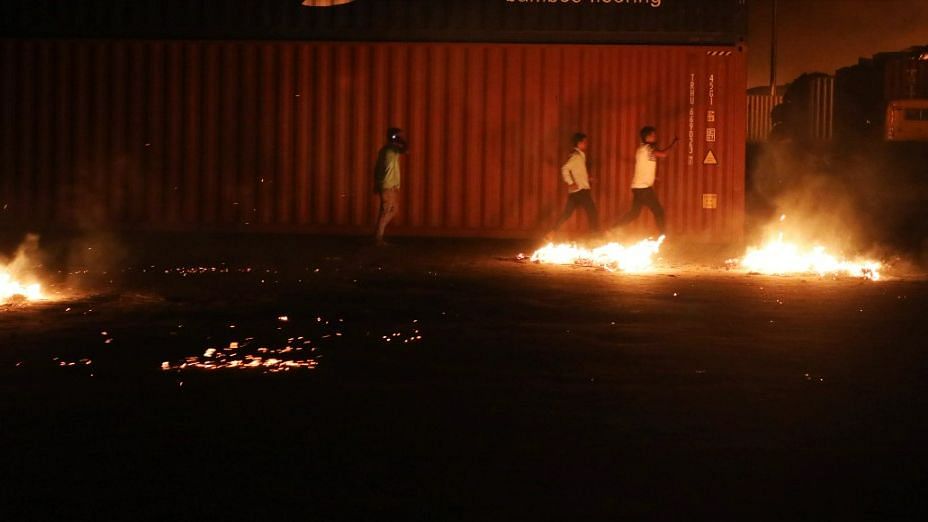 <div class="paragraphs"><p>Unidentified men run after a fire broke out at BM Inland Container Depot, a Dutch-Bangladesh joint venture, in Chittagong, 216 kilometres (134 miles) southeast of capital, Dhaka, Bangladesh, early Sunday, 5 June, 2022.</p></div>
