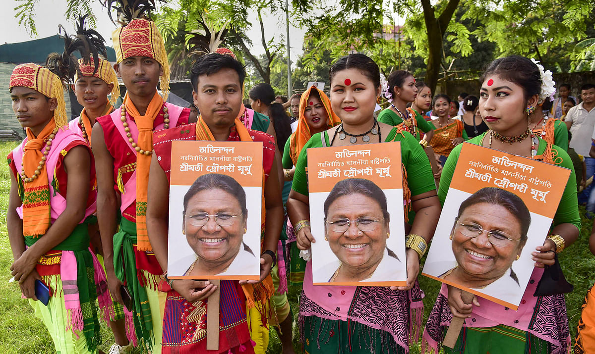 <div class="paragraphs"><p>Artists belonging to Tiwa community hold photos of NDA Presidential candidate Droupadi Murmu, as she leads during counting of votes to elect the 15th President, in Guwahati</p></div>