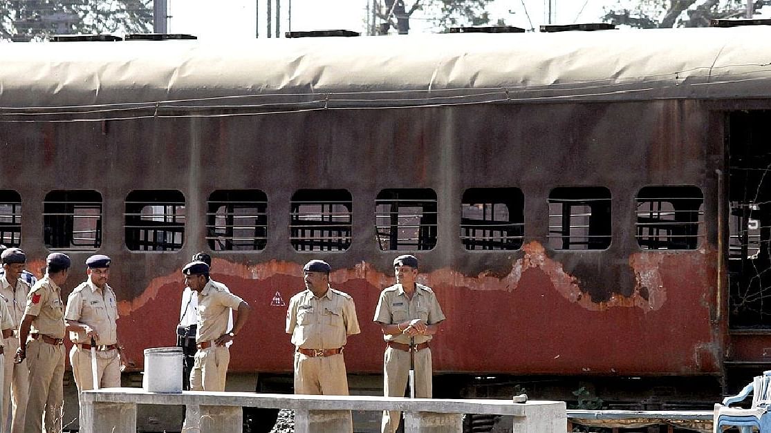 Police guard a train coach that was set ablaze in Godhra in 2002.&nbsp;