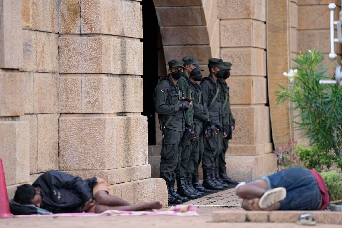 <div class="paragraphs"><p>Army soldiers stand guard as protesters sleep by the entrance to president's office in Colombo, Sri Lanka, on Friday, 15 July. </p></div>