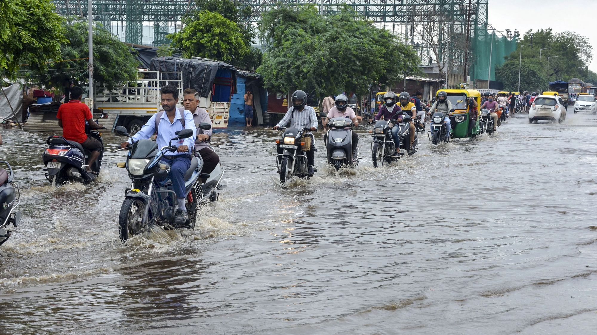 <div class="paragraphs"><p>Ahmedabad: Commuters wade through a waterlogged street after heavy rain in Ahmedabad, Monday,11 July.</p></div>