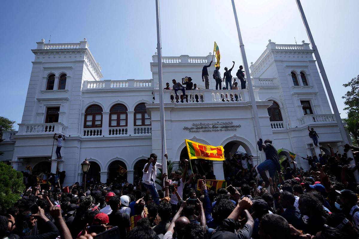 <div class="paragraphs"><p>Sri Lankan protesters storm the compound of Prime Minister Ranil Wickremesinghe 's office on Wednesday, 13 July, demanding he resign after president Gotabaya Rajapaksa fled the country amid economic crisis in Colombo.</p></div>