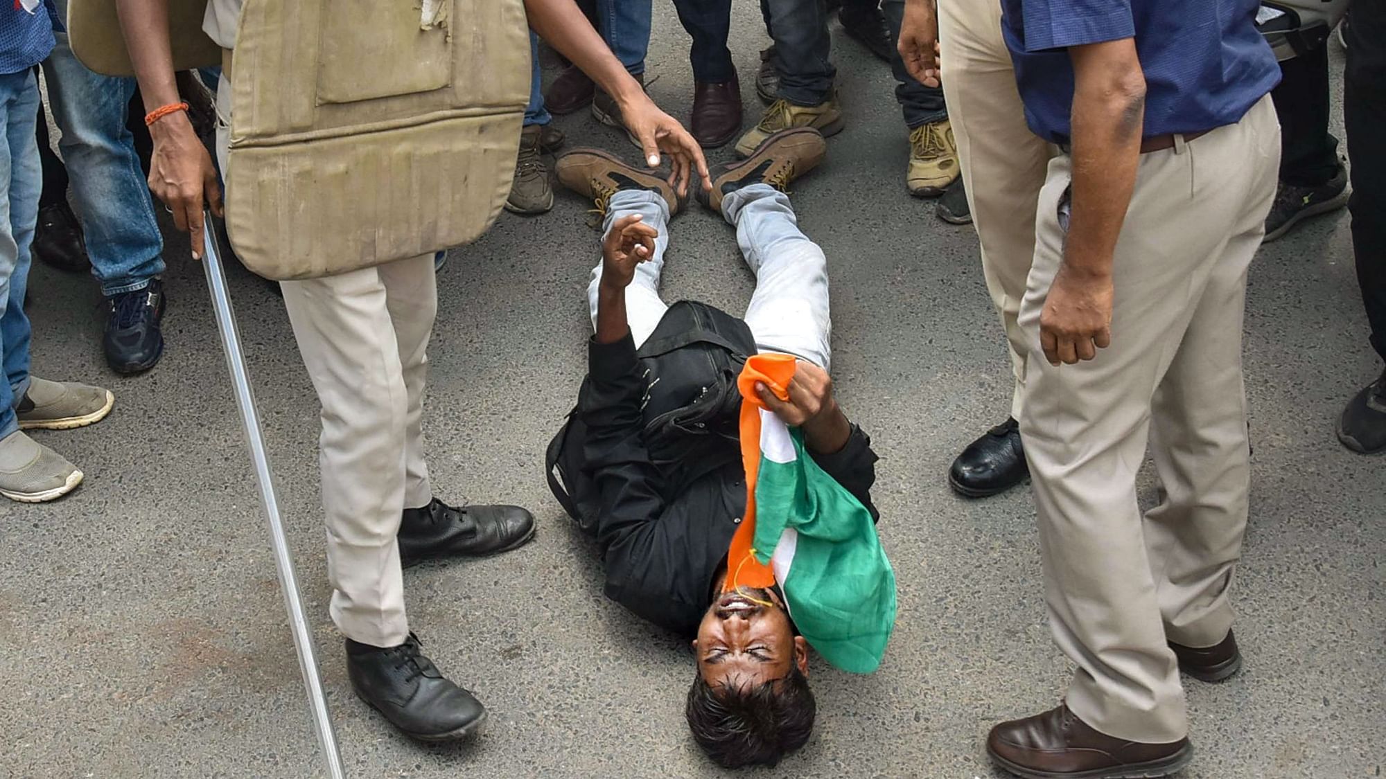 <div class="paragraphs"><p>A candidate lies on the road after he was hit by Additional District Magistrate (Law &amp; Order) KK Singh with a baton during a protest in Patna, on 22 August 2022.</p></div>