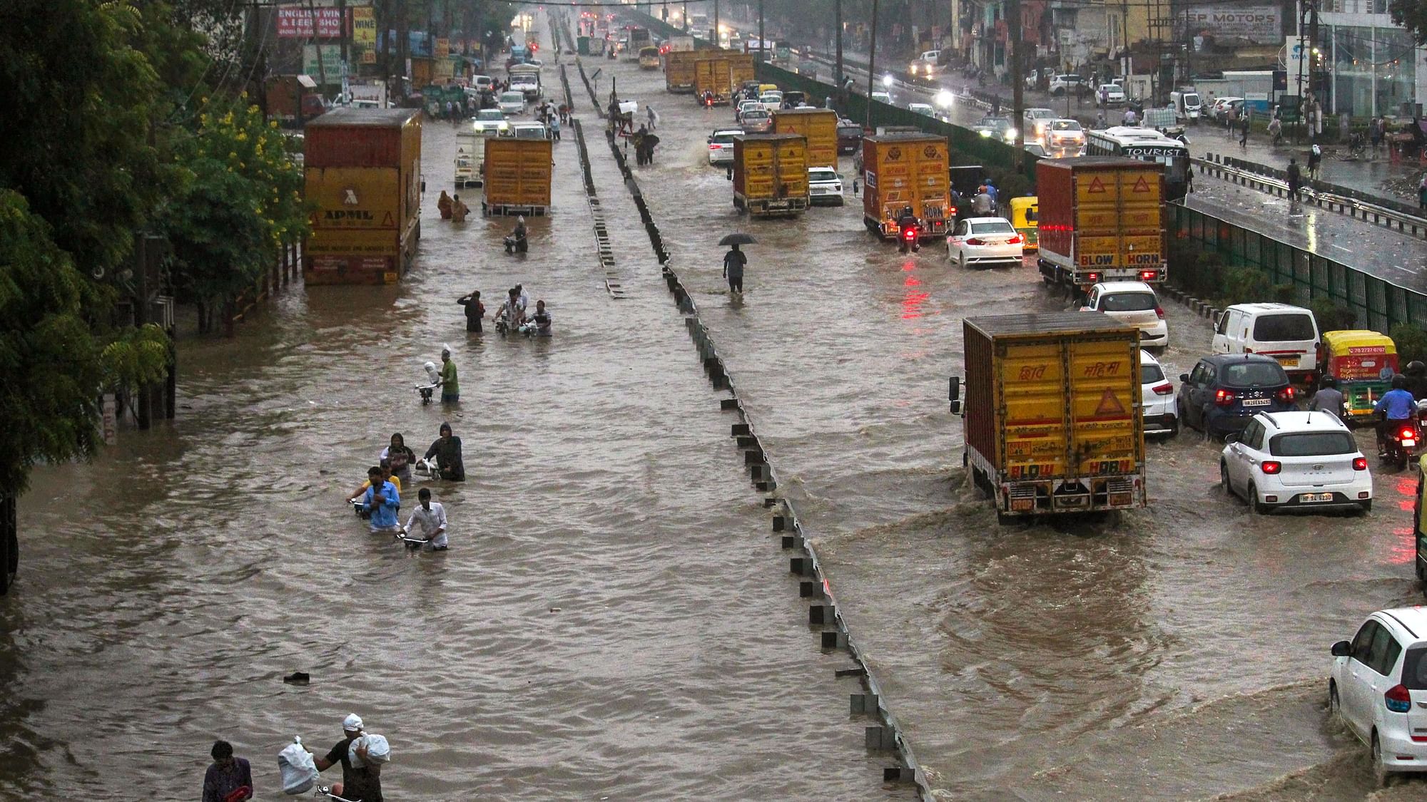 <div class="paragraphs"><p>Commuters wade through a waterlogged Delhi-Gurugram Expressway and its service road after rainfall, in Gurugram on 22 September.</p></div>