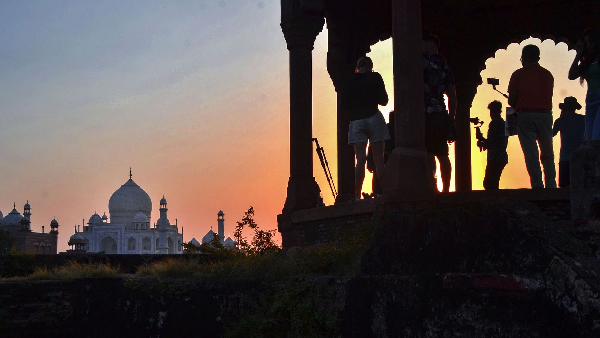 <div class="paragraphs"><p>Tourists taking photos of the Taj Mahal at sunset in Agra on Thursday, 29 September.</p></div>